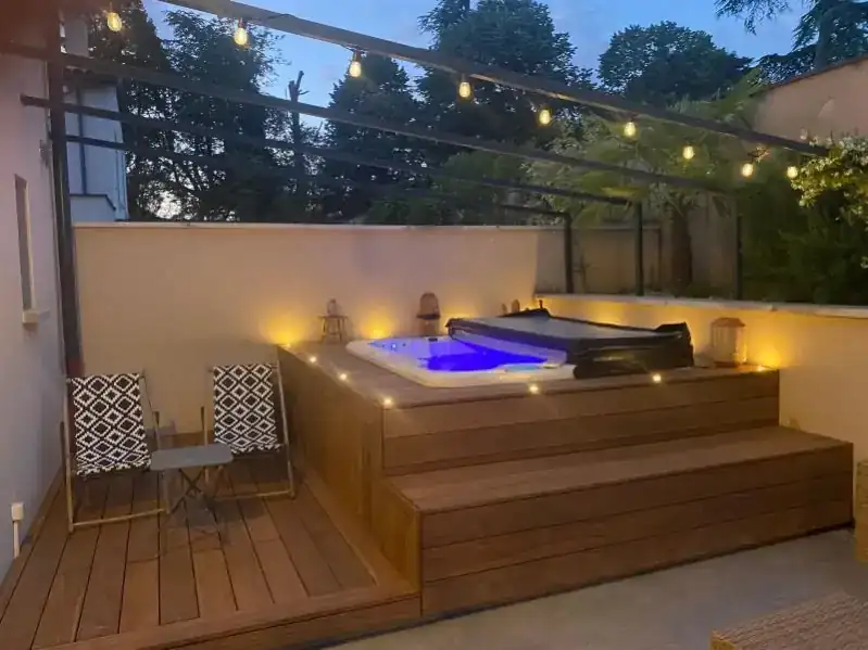 Spa extérieur sur terrasse bois exotique illuminée